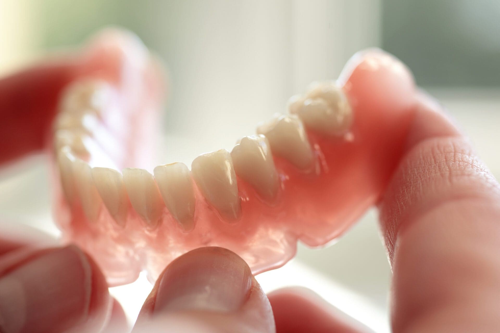Dentures held up by an oral surgeon in dothan al